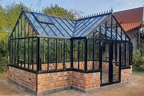 Gewaechshaus mit halbhoher Ziegelmauer im Orangerie-Design