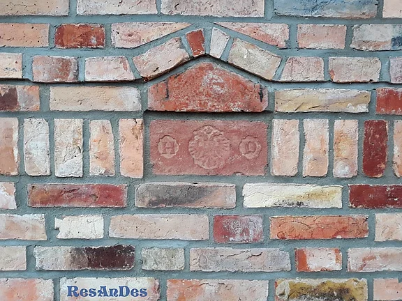 Ziegelmauer mit alten Schmucksteinen