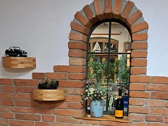 Ziegelriemchen als Wandverkleidung rund um ein Fenster mit gemauerter Fensterlaibung