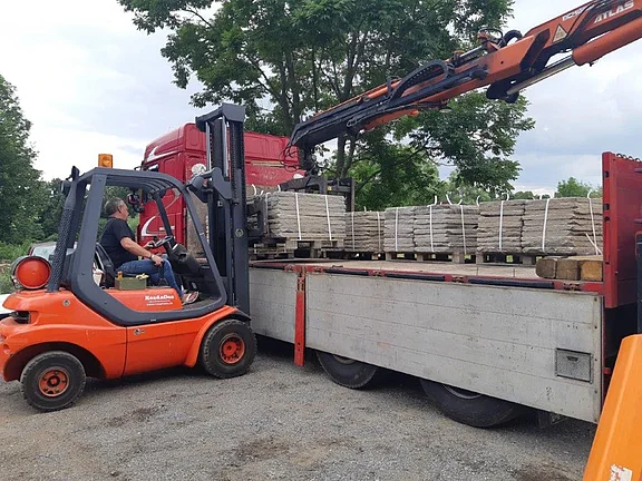 Stapler verlädt palettierte alte Ziegel auf LKW zur Lieferung