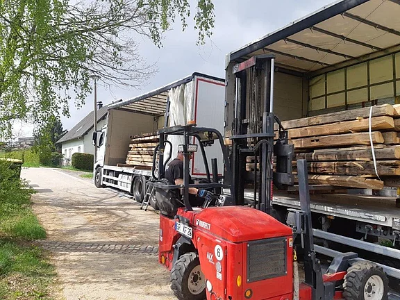 Stapler belädt LKW mit alten Holzbalken und historischen Bauhölzern in der Oberlausitz