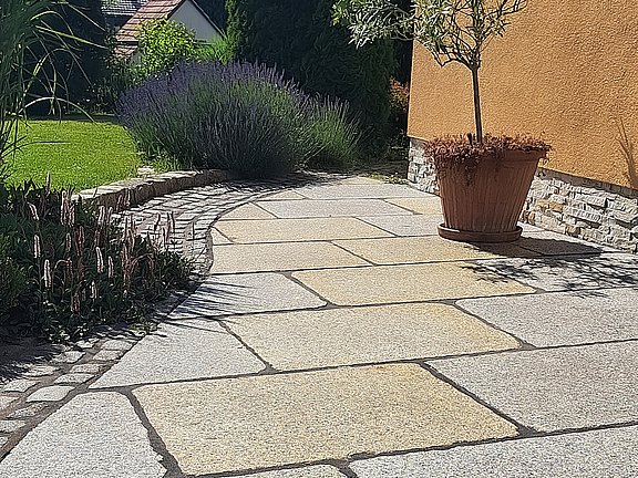 Granitplatten vor Eigenheim mit Granitpflastersteineinfassung und Rasenfläche